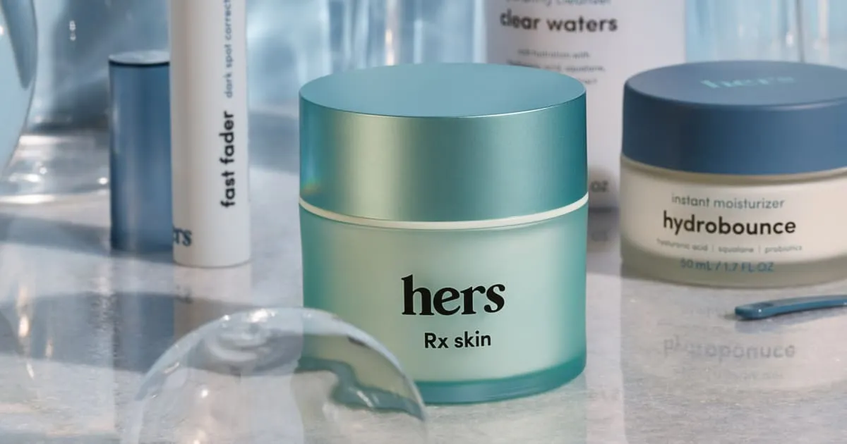 Hers' own photo of a teal jar labeled Rx skin on a counter, with a Hers cleanser, moisturizer and dark spot product behind it.